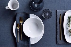 Tavola con tovaglia in lino indaco e stoviglie bianche e blu