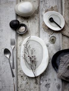 Tavola apparecchiata senza fronzoli e con piatti ovali dalla forma irregolare