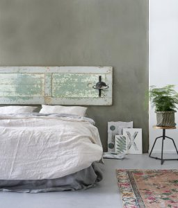 Una vecchia porta in legno viene utilizzata come testiera