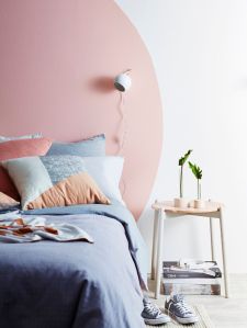 Una testiera dipinta facendo un enorme cerchio rosa sul muro