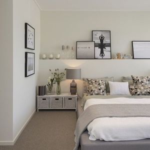 Mensola sopra al letto lunga come tutta la parete alle spalle del letto con quadri, vasi e candele