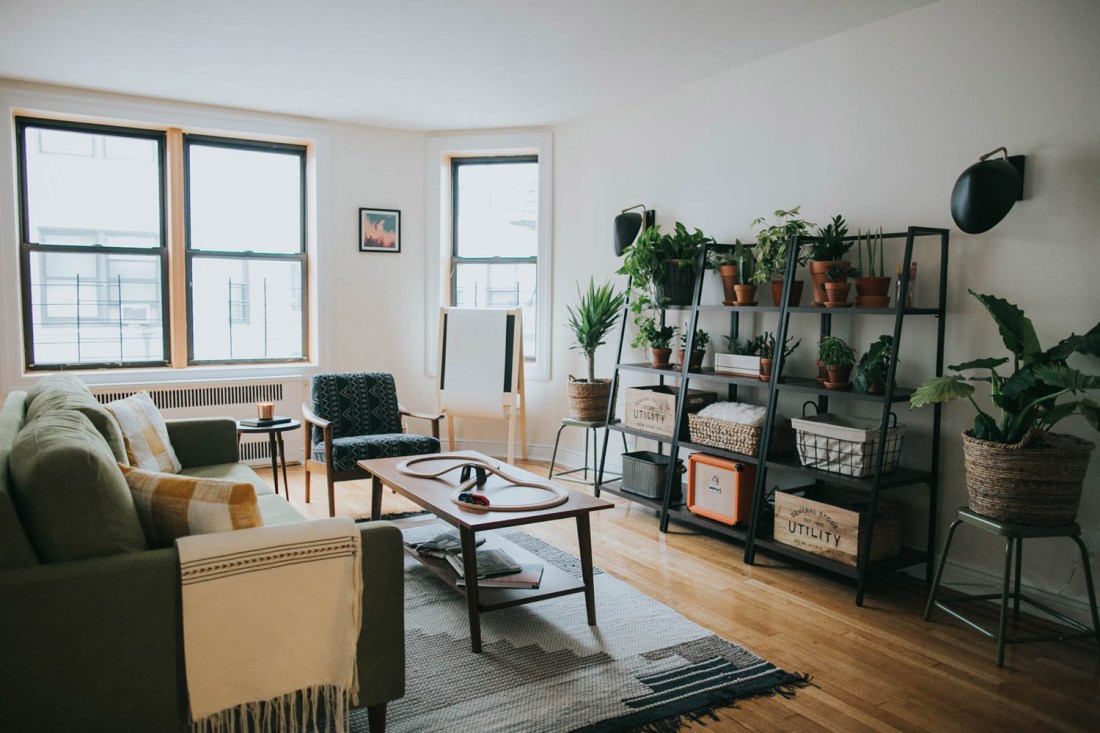 Soggiorno minimal con divano e scaffali in ferro