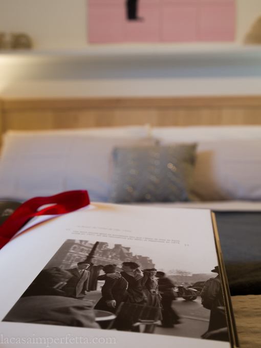 Stanza sulle tonalità del grigio con qualche tocco di rosa e rosso con dettaglio su "Il bacio" di Doisneau