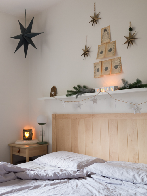 Camera da letto con ghirlanda, candele, stelle ed albero di Natale creato con pagine di vecchio libro