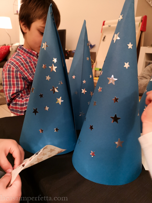 I bambini decorano ognuno il proprio cappello con delle stelline adesive