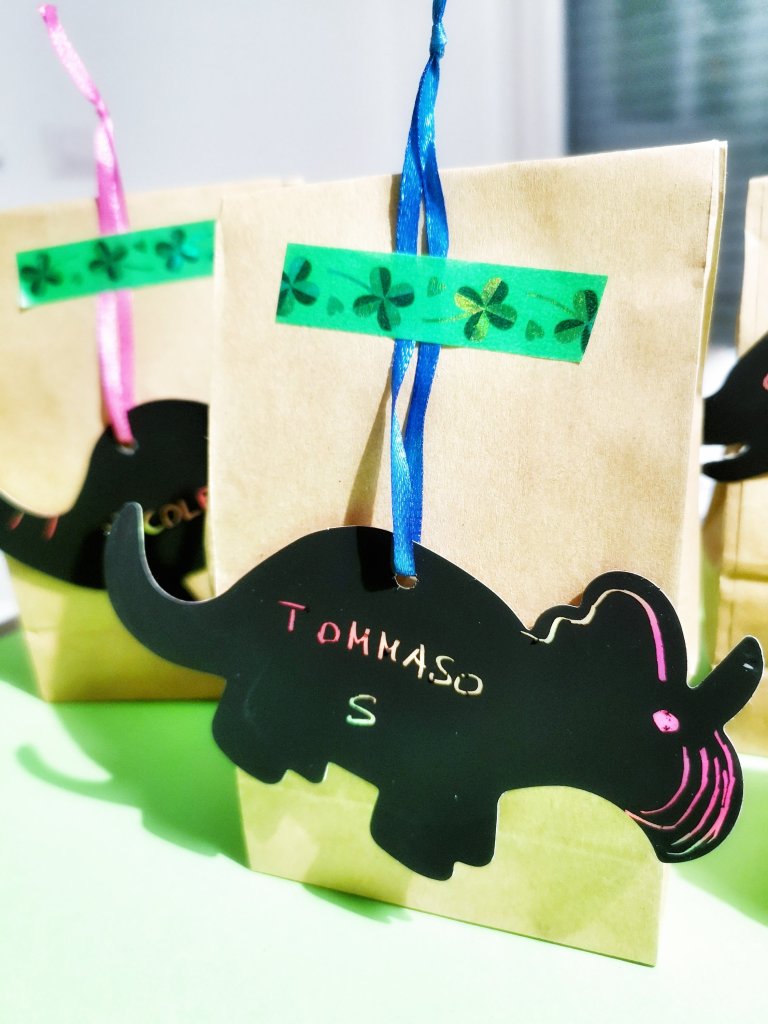 Sacchetti in carta kraft con dinosauri scratch art coi nomi di partecipanti