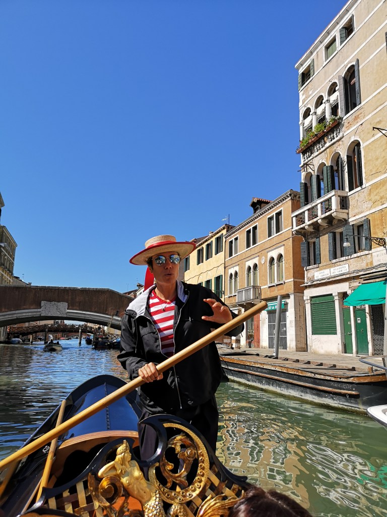 foto scattata dalla gondola con in primo piano la prima gondoliera donna di Venezia